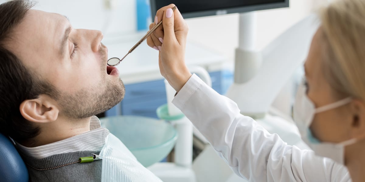 female dentist examining patient - Forestbrook Dental